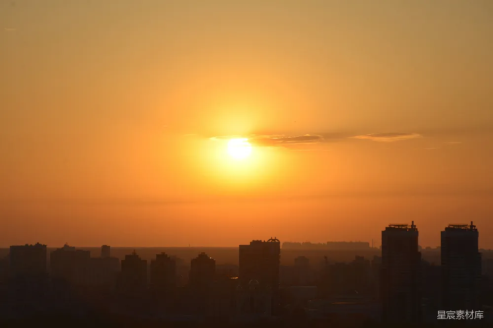 这张图片捕捉到了城市日落时的宁静与美丽。夕阳的金光洒在城市的轮廓上，形成了一幅剪影效果，给人一种平静而祥和的感觉。适合用作城市风光或自然风光的背景图片。