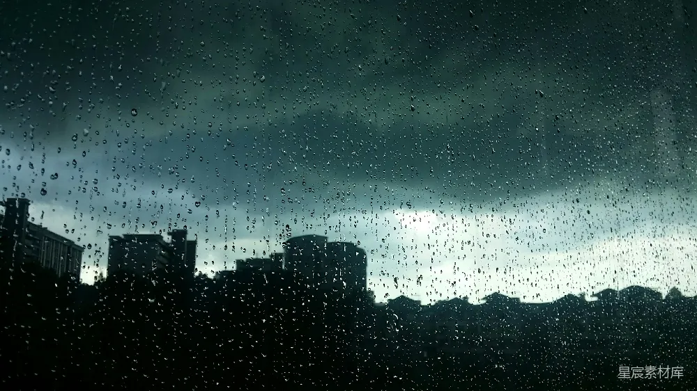 这张图片展示了一个雨后的城市剪影，透过窗户可以看到城市建筑的轮廓和天空中飘动的云彩。雨水在玻璃上留下了晶莹的水滴，增加了画面的立体感和质感。整体色调偏冷，营造出一种静谧而略带忧郁的氛围，适合用于表现雨后城市静谧的时刻。