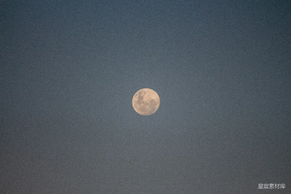 这张图片展示了一个宁静的夜空，中央是一轮明亮的满月。深邃的夜空背景与月亮的光亮形成了鲜明的对比，营造出一种宁静而神秘的氛围。适合用于表现宁静、自然或摄影主题的背景图。