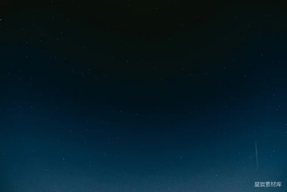 这张图片展示了一个宁静的夜空景象，满天繁星点缀其中，天空从深蓝渐变至黑色，下方有一道流星划过，增添了画面的动感与神秘感。这种场景适合用作自然风光、宁静氛围或夜景的背景素材。