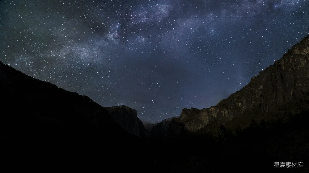 这张图片展示了夜空中璀璨的星星和银河，银河横跨画面，背景是黑暗的山脉轮廓。整个场景显得宁静而神秘，适合用于自然风光、天文摄影、宁静夜景等主题。