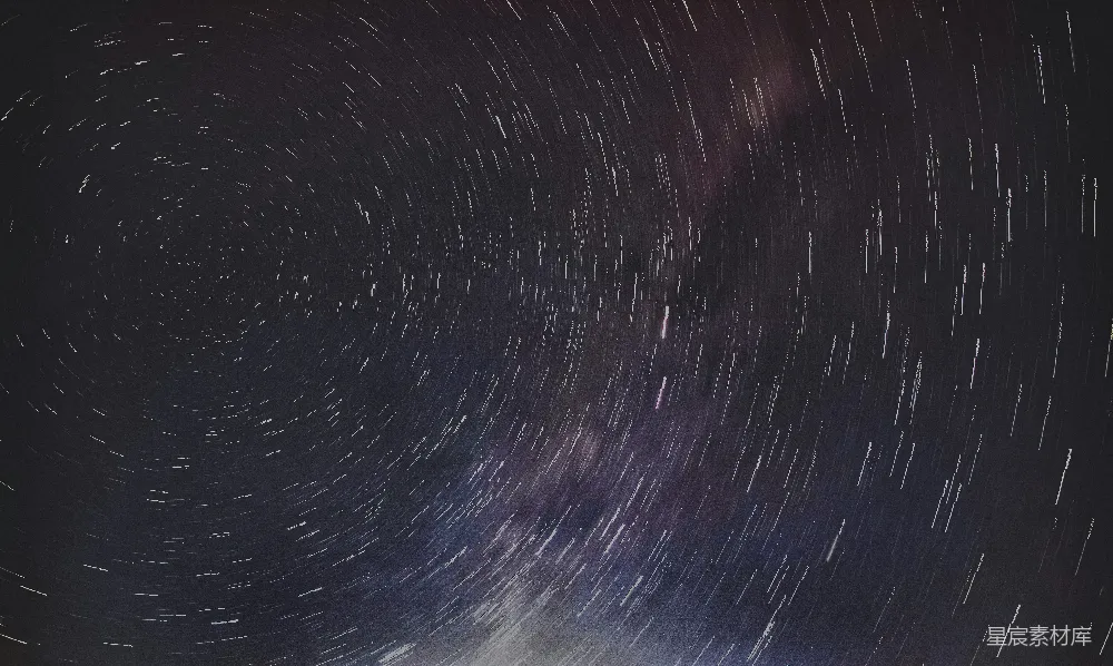 这张图片展示了夜晚天空中星体的旋转轨迹，形成了美丽的星轨效果。深邃的黑色背景与白色的星轨形成鲜明对比，给人一种神秘而宁静的感觉。这种照片常用于展示宇宙的壮丽景象，适合用作天文摄影爱好者的作品展示或自然风光的背景。