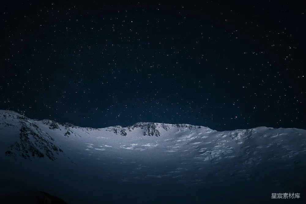 这张图片展示了在静谧的夜晚，雪山覆盖着厚厚的积雪，繁星点点的天空与地平线上的雪山形成鲜明对比。画面呈现出一种宁静而神秘的氛围，适合用于自然风光的海报或旅行宣传材料。