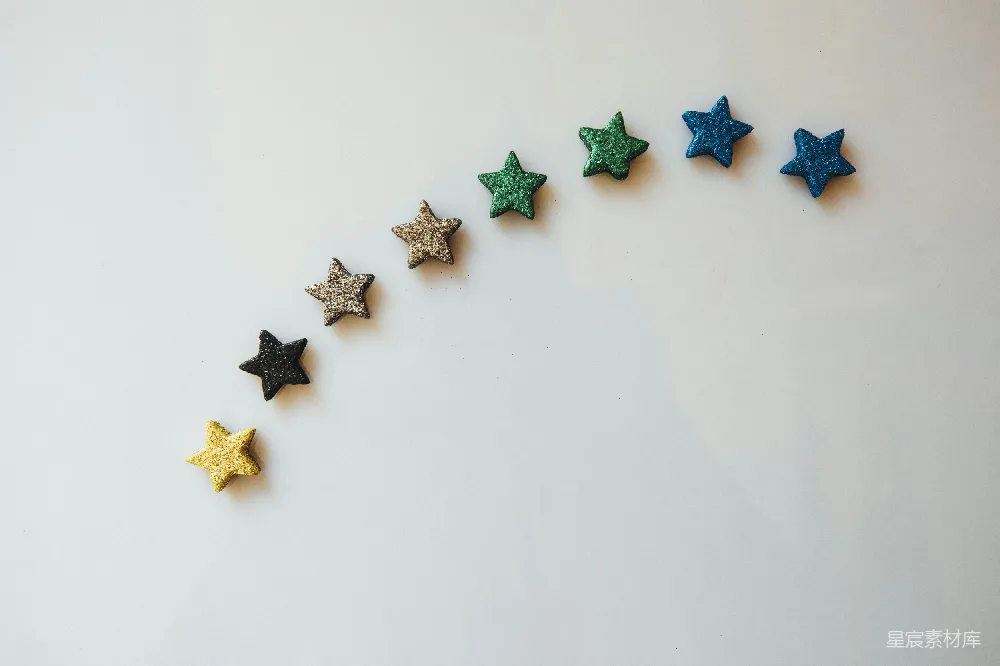 图片展示了一排渐变色的星星，从黄色到蓝色依次排列。星星在白色背景上显得格外醒目，整体风格简洁而富有创意，适合用于节日装饰、儿童活动或艺术创作中。