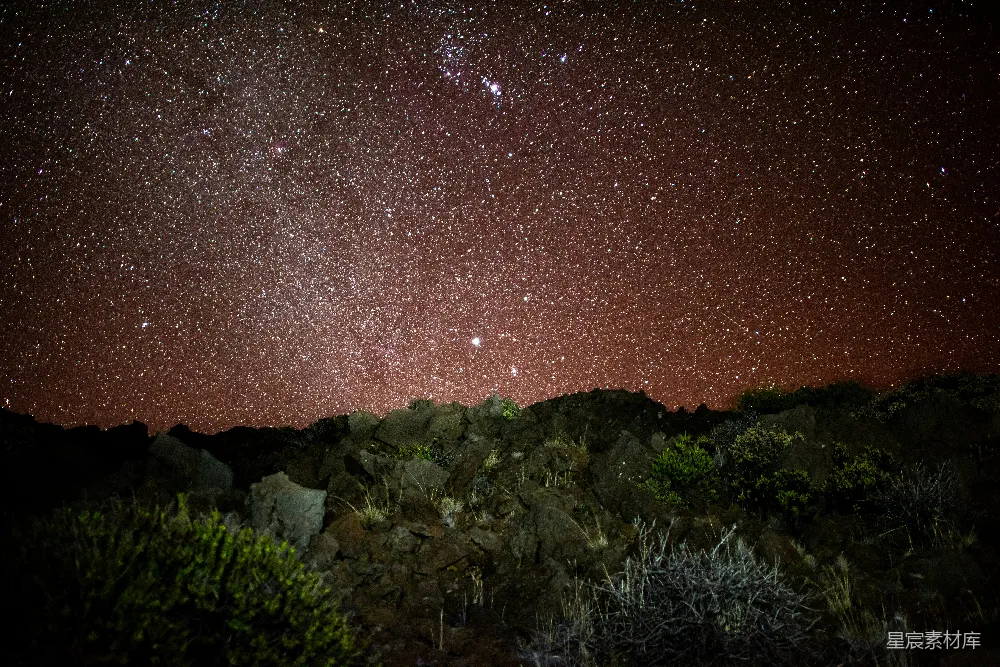 这张图片展示了在夜空中繁星点点的景象，岩石在前景中显得格外突出，营造出一种宁静而神秘的氛围。适合用于展现自然之美，或者作为背景素材用于纪录片或电影的场景设置。
