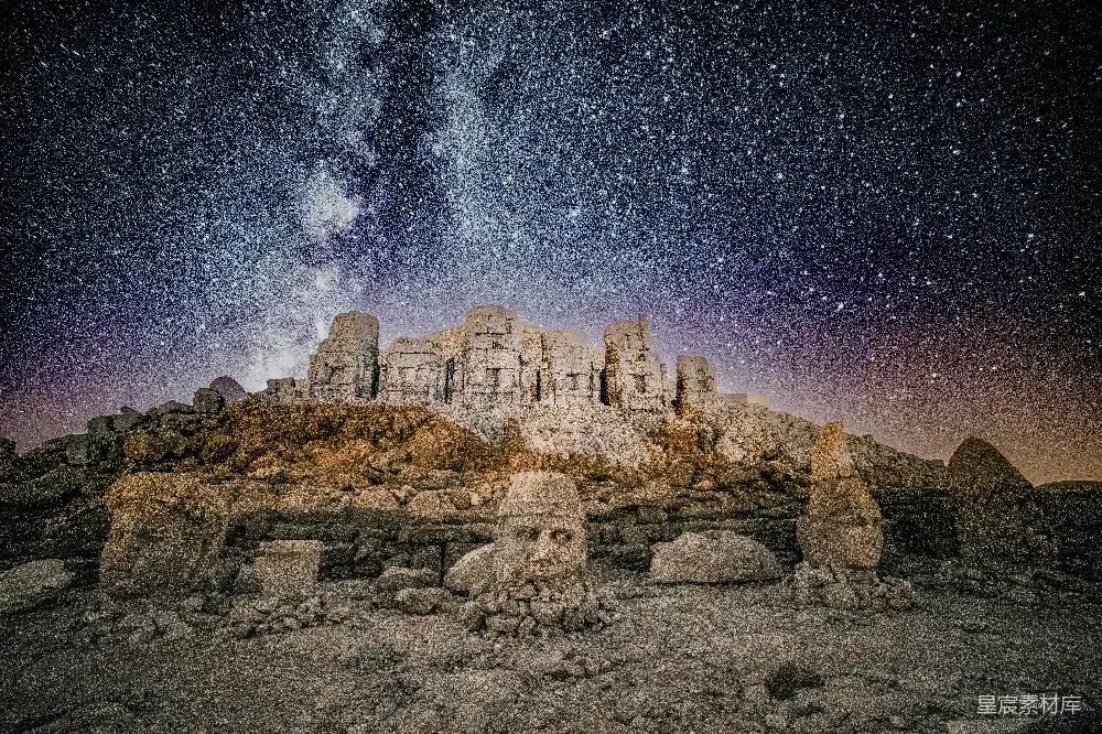 这张图片展示了一片废墟在星空下的景象。废墟上覆盖着一层薄薄的植被，背景是满天的星星和银河，营造出一种神秘而宁静的氛围。废墟的残垣断壁与璀璨的星空形成了鲜明的对比，给人一种历史与自然交织的感觉。适合用作旅行、探险或历史主题的背景图片。