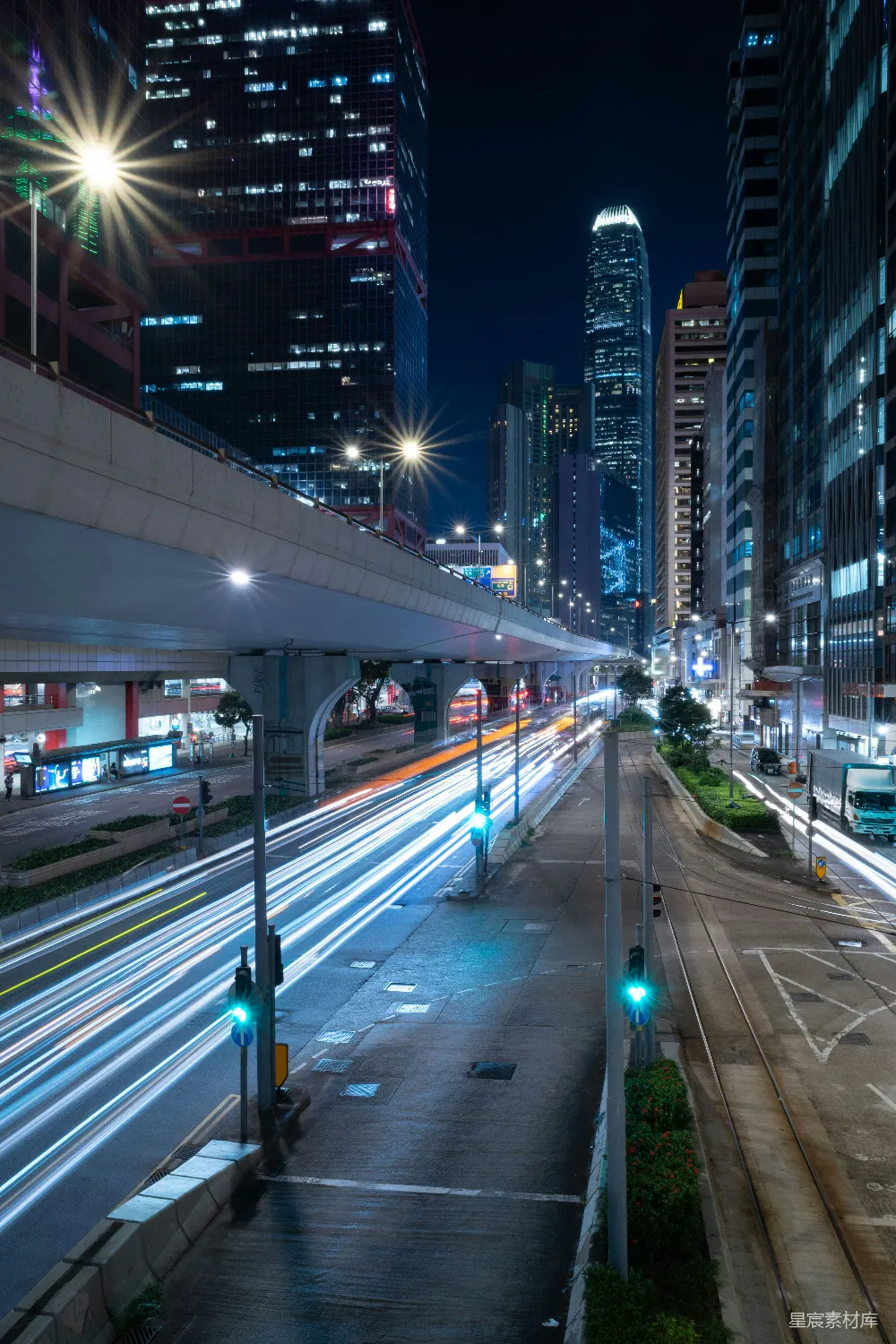 这张图片展示了城市夜景的延时摄影效果。画面中，高楼大厦的灯光与街道上的车辆灯光交织在一起，形成了一幅充满动感与活力的城市夜景图。灯光的拖影效果使得整个画面充满了现代都市的氛围。
