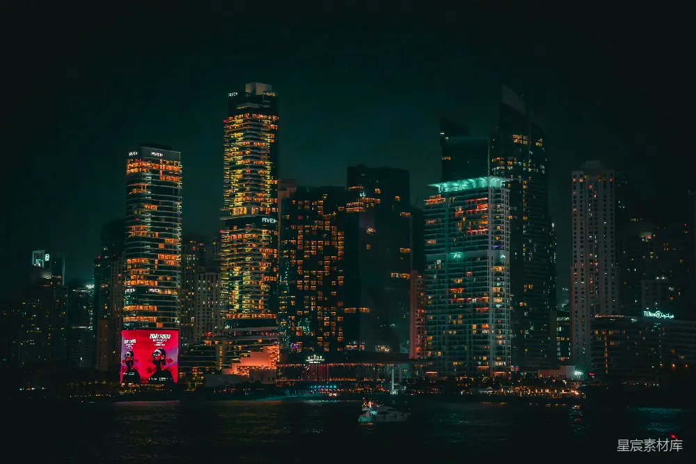 这张图片展示了城市夜景中的摩天大楼，灯光璀璨，氛围繁华。高楼大厦错落有致，灯光在黑暗中显得格外醒目，营造出一种现代都市的繁华与活力。图片中的夜景适合用于描述城市夜生活、都市风情或都市夜景的主题。