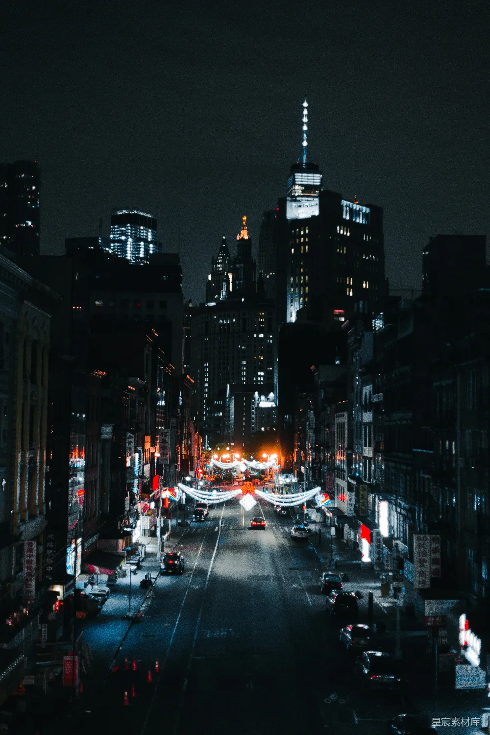 这张图片展示了夜晚城市的景象，高楼大厦的灯光在黑暗中显得格外耀眼，街道两旁的霓虹灯闪烁着五彩斑斓的颜色。整幅画面给人一种繁华而又宁静的感觉，适合用作城市夜景、都市夜景、高楼大厦等主题的背景素材。