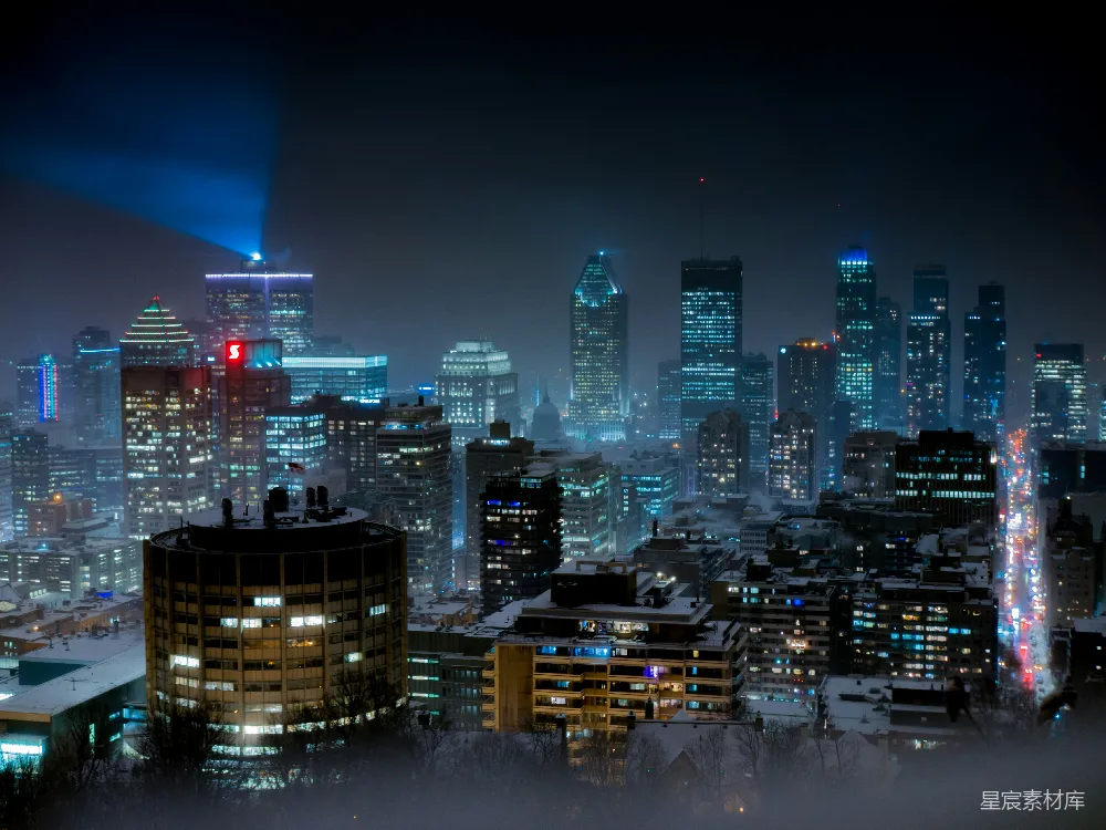 这张图片展示了城市在夜晚的景象，灯光点缀其中，远处的高楼大厦在雾气中若隐若现，营造出一种神秘而宁静的氛围。