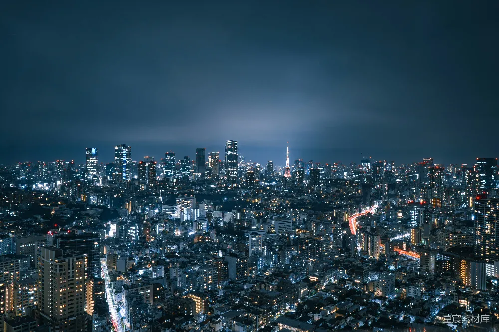 这张图片展示了东京夜间的城市天际线，灯光璀璨，高楼大厦错落有致，其中东京塔尤为显眼。背景中深邃的夜空与城市的灯火形成鲜明对比，营造出一种宁静而又繁华的氛围。这张图片适合用于城市风光、旅游宣传或现代都市生活主题。