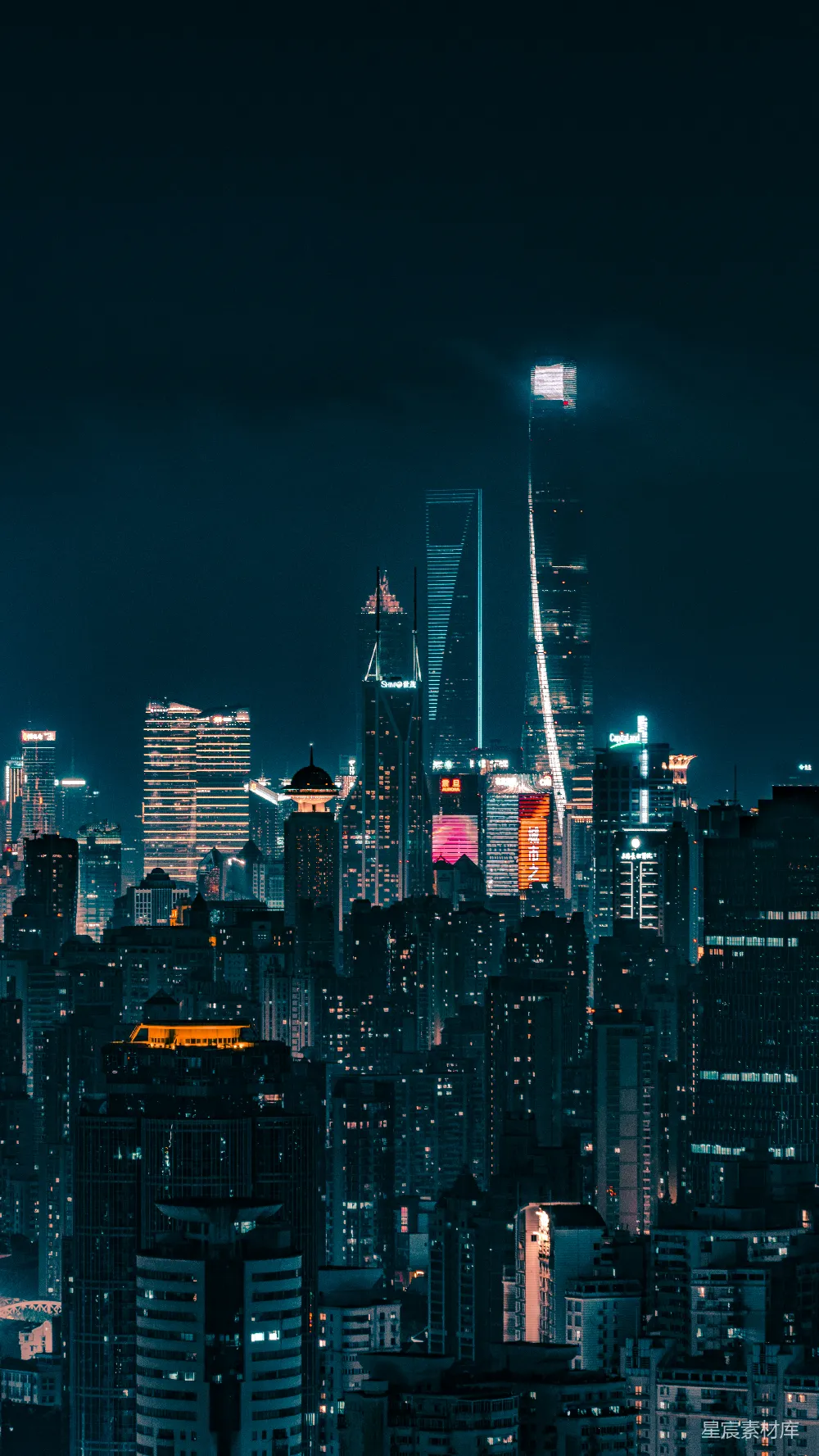 这张图片展示了夜晚城市的全景，高楼大厦灯火通明，灯光在夜空中形成璀璨的线条，给人一种现代都市繁华的感觉。适合用作城市夜景、现代都市、建筑灯光、夜景摄影或都市繁华等主题的背景图。