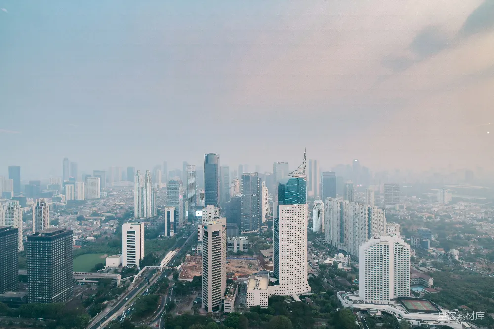 这张图片展示了城市的天际线，高楼大厦林立，道路和桥梁交织，远处的天空中飘着几朵云，整体色调偏蓝，给人一种宁静而现代的感觉。适用于城市风光、建筑设计、城市规划等场景。
