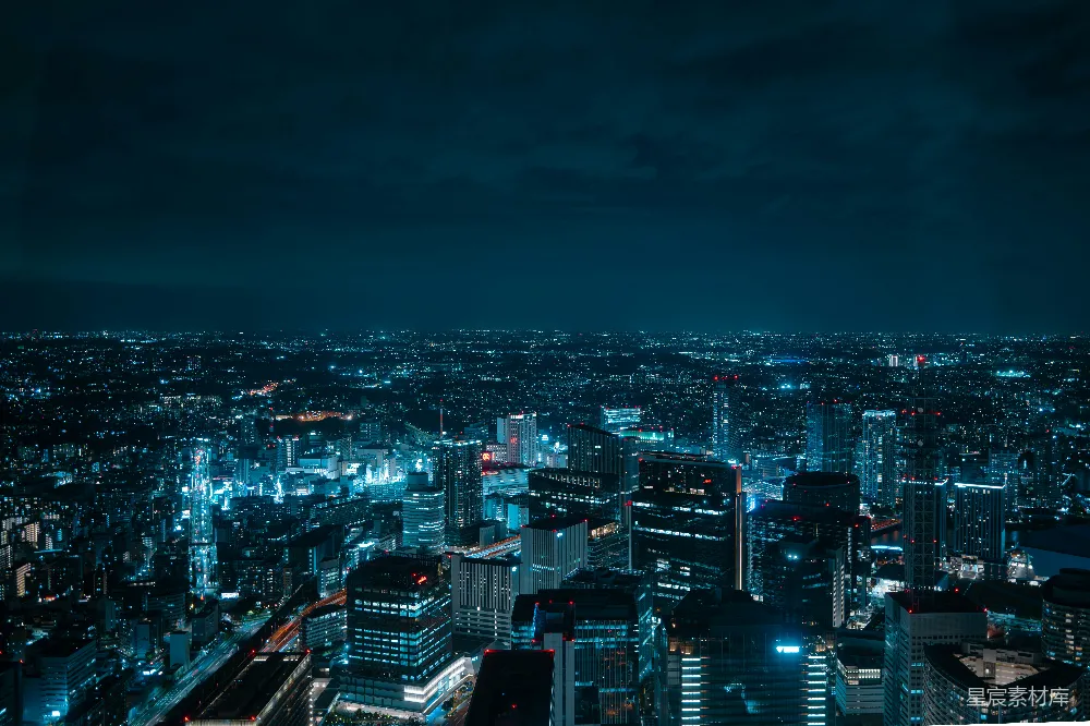 这张图片展示了夜晚城市繁华的景象，蓝色的夜空下，高楼大厦灯火辉煌，街道上车流如织，构成一幅现代都市的夜景图。适合用于城市风光、现代生活或夜景摄影相关的内容展示。