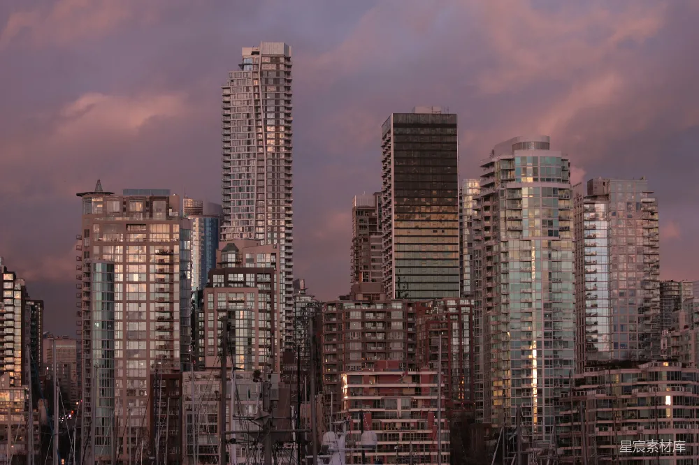 这张图片展示了城市天际线在日落时分的美丽景象。高楼大厦在夕阳的映照下显得格外壮观，云层被染上了温暖的色调，营造出一种宁静而梦幻的氛围。背景中的建筑物错落有致，反射出夕阳的光辉，给人一种现代都市的繁荣与活力。