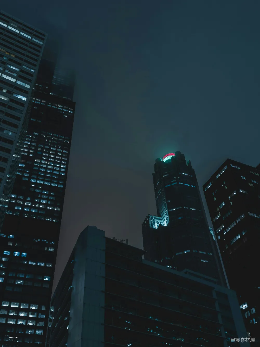 这张图片展示了夜晚城市中的高楼大厦，灯光透过窗户洒出，营造出一种静谧而神秘的氛围。建筑物在夜色中显得格外引人注目，顶部的灯光点缀在黑暗中，仿佛引领着夜行者前行。整体风格呈现出一种都市的现代感与宁静感，适合用于表现城市夜景、都市生活或现代建筑
