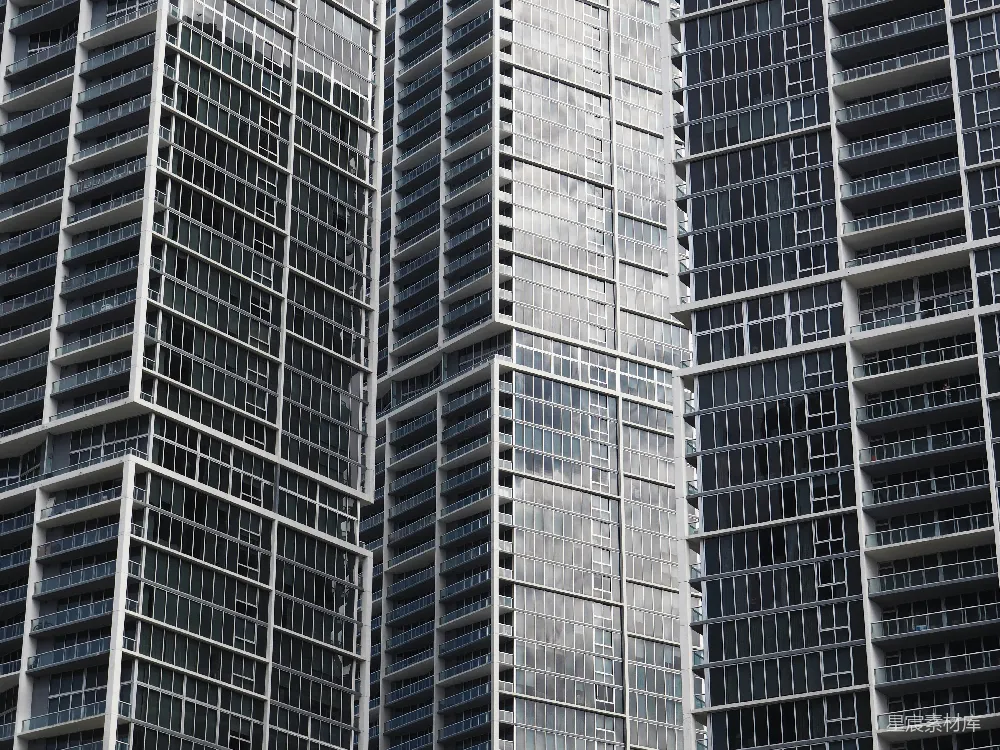 这张图片展示了一组现代高层公寓建筑，每栋楼都拥有大量的阳台和窗户，玻璃幕墙反射出周围的环境。这种建筑风格常见于大城市，体现了都市生活的密集与高效。