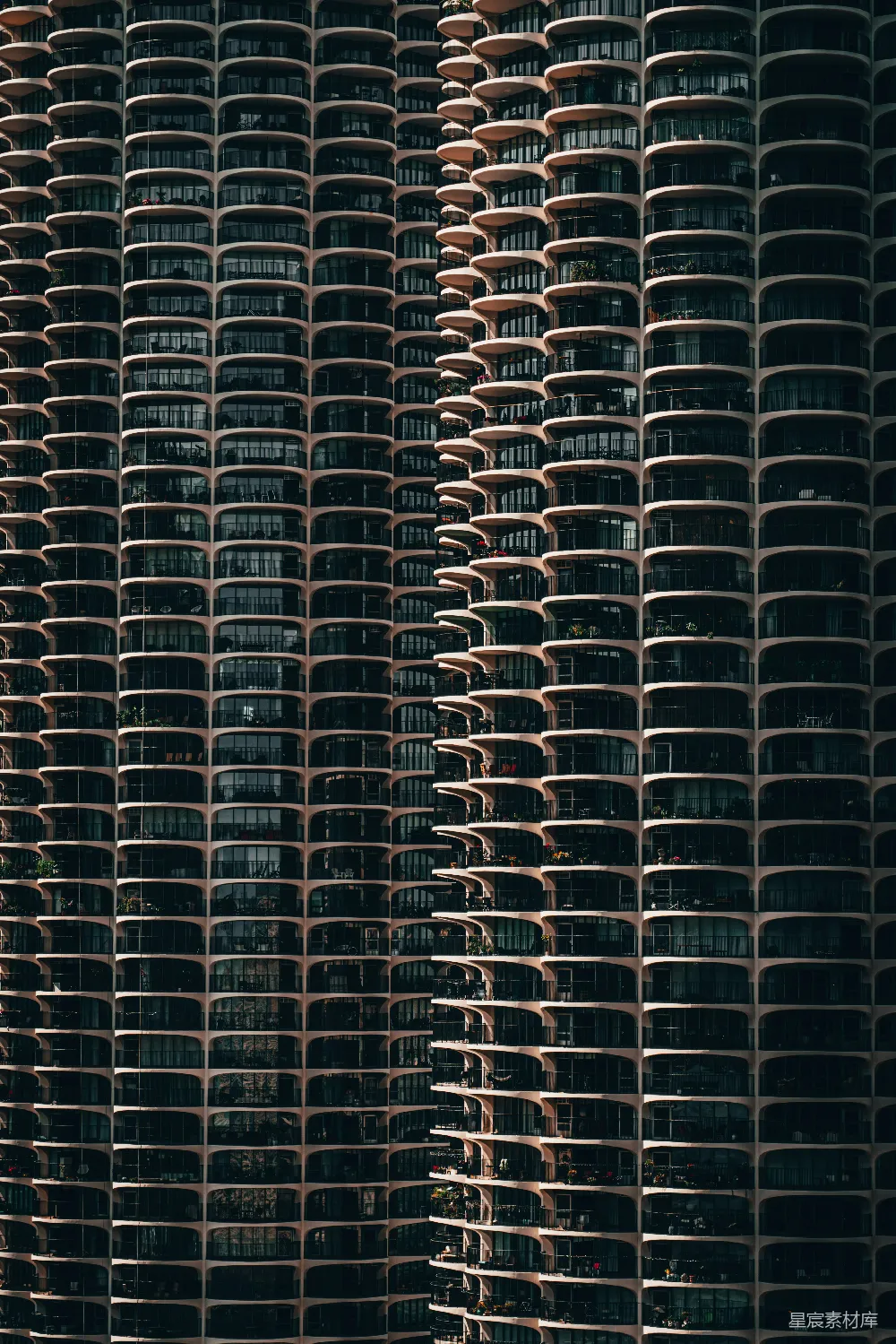 这张图片展示了芝加哥著名的Marina City建筑群，其独特的曲面设计使其在众多建筑中脱颖而出。这座建筑由两座高塔组成，每座高塔由一系列半圆形单元组成，呈现出独特的流线型外观。这个设计不仅美观，还为居住者提供了良好的视野和采光。图片展示了