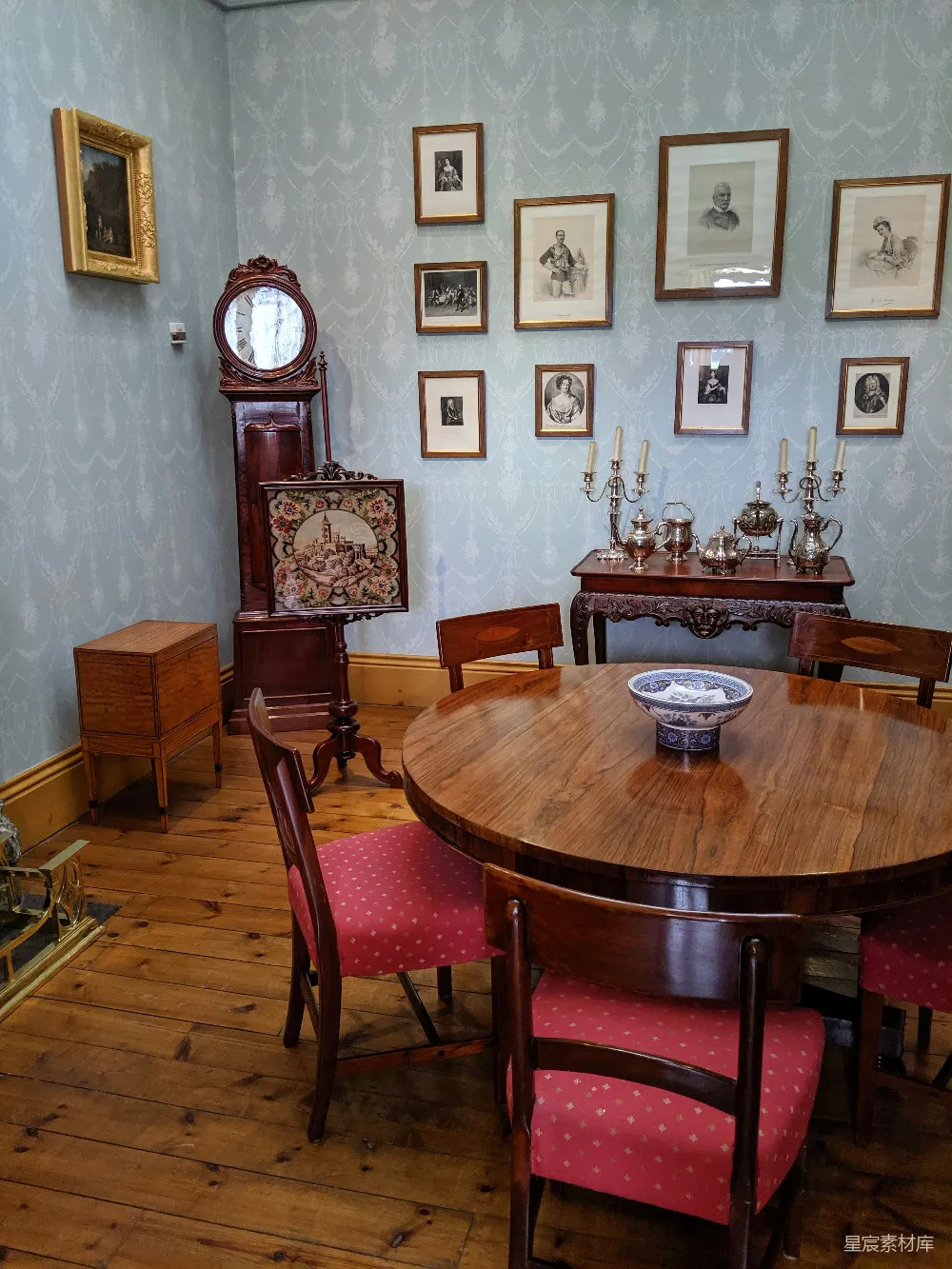 这张图片展示了一个复古风格的餐厅，墙上挂满了复古风格的画框，桌椅和摆件都带有浓厚的古典气息，适合历史爱好者或喜欢复古风格的人参观或装饰。