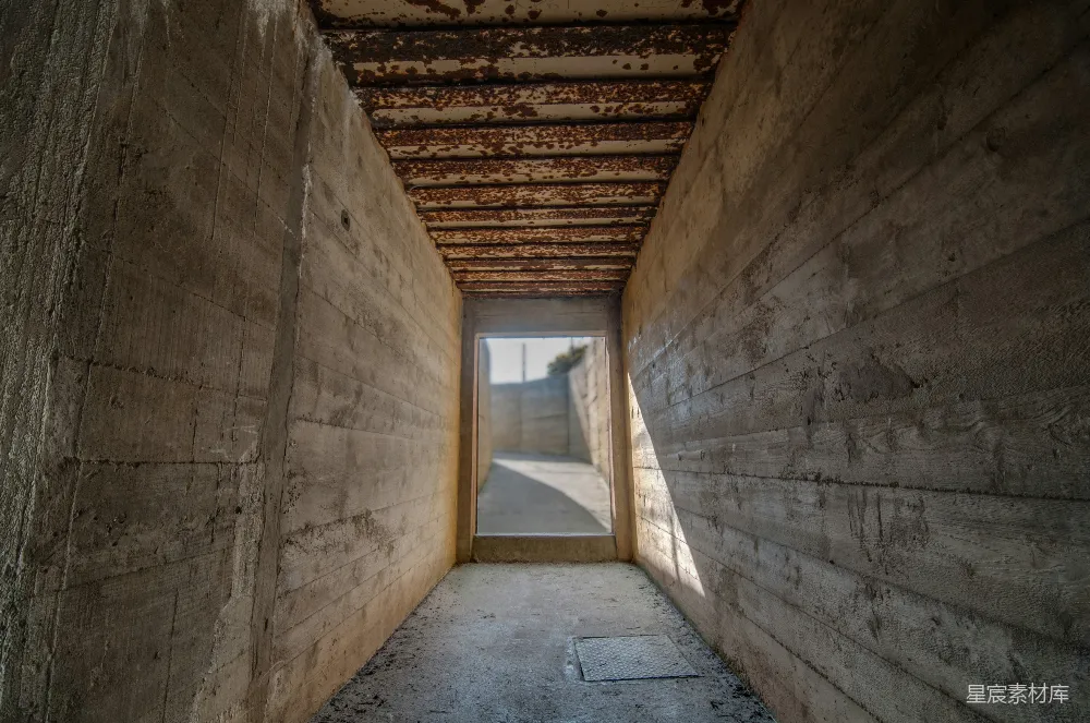 废弃隧道内，阳光透过上方的缝隙洒下斑驳的光影，墙面和天花板斑驳的油漆和锈迹透露出岁月的痕迹。这种场景适合用作废墟、历史、探险等主题的背景。