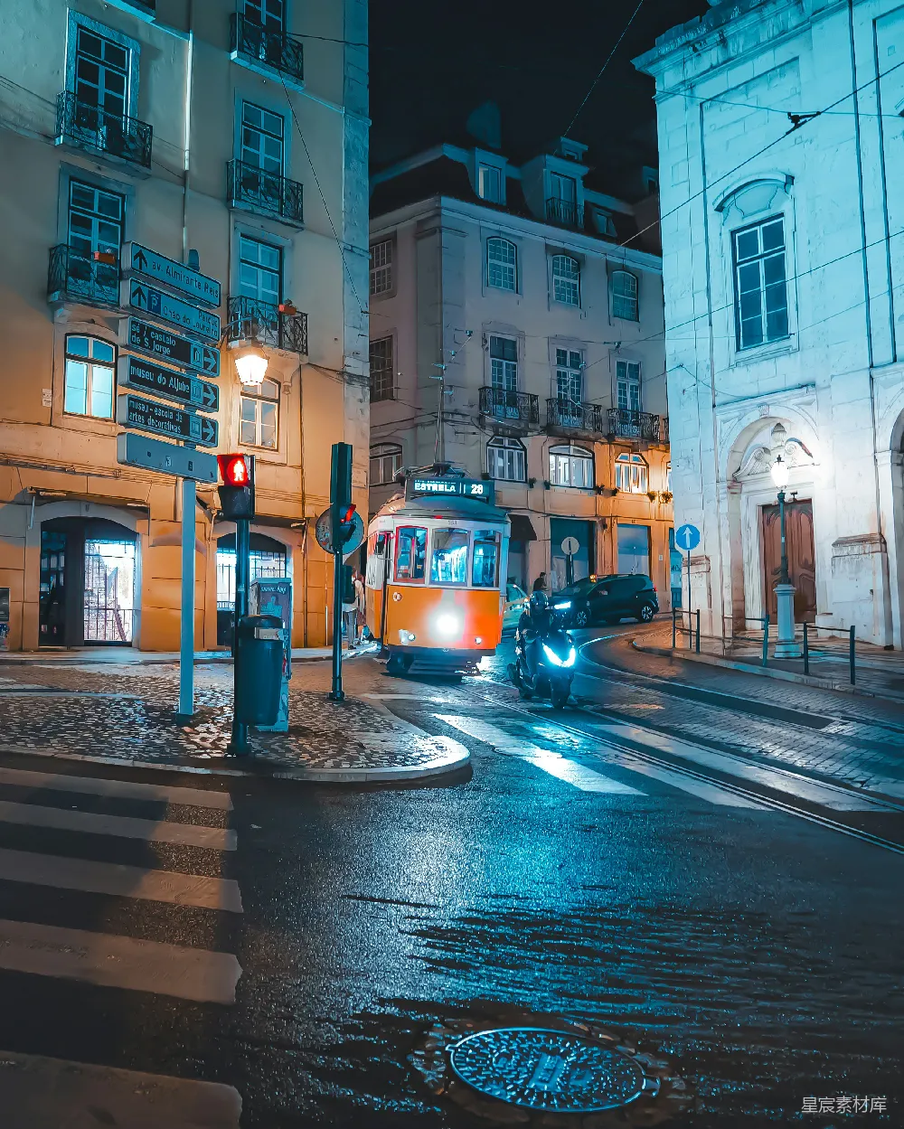 夜晚的城市街景，电车在雨后的街道上行驶，灯光映照在湿润的地面上，营造出一种静谧而独特的氛围。建筑物的灯光与电车的车灯交织，呈现出一种温暖而梦幻的视觉效果。