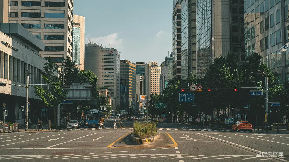 高清摄影  路旁近高层建筑处的车在白天行驶。
