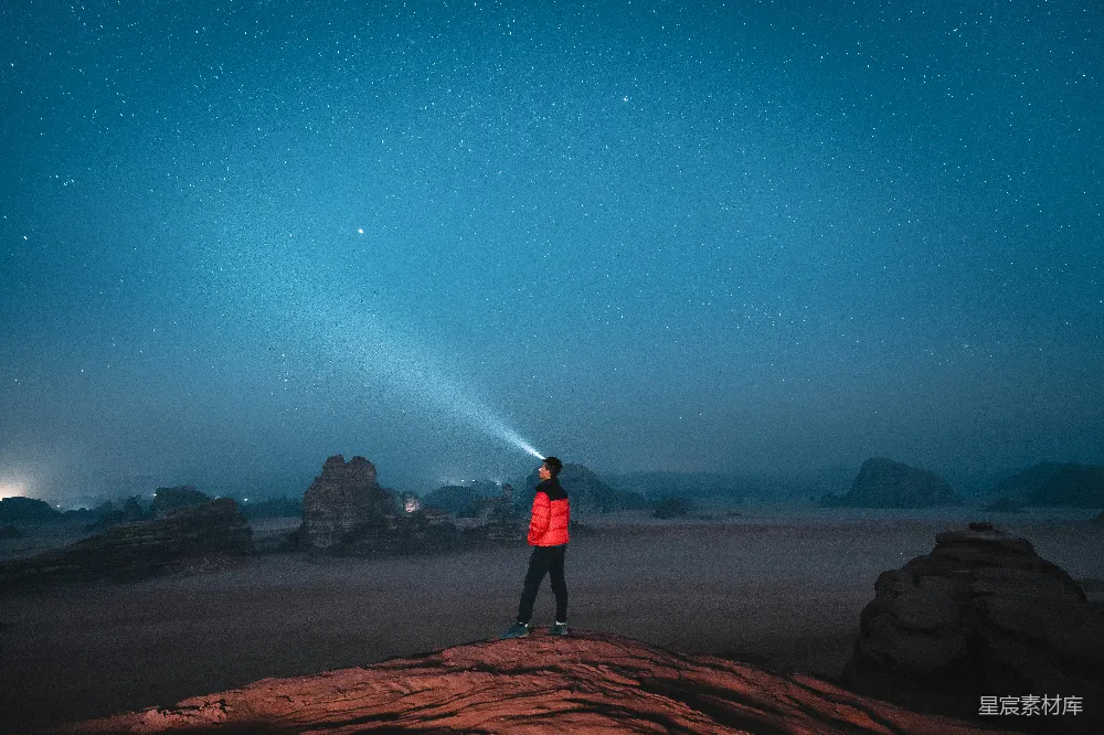 高清摄影 旅行 一个人站在岩石上，天空中繁星点点。