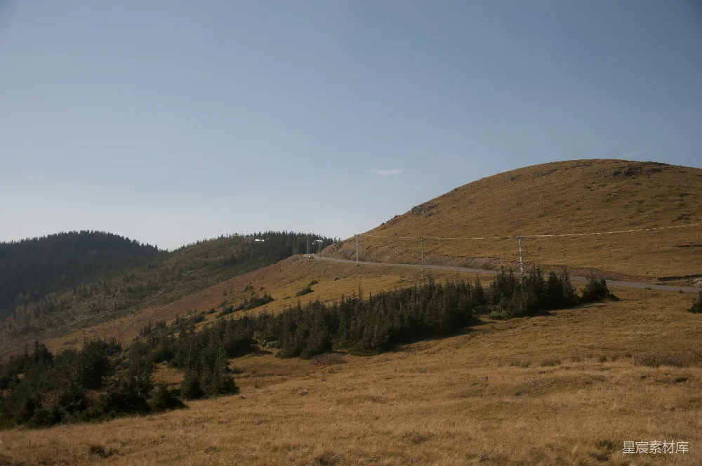 高清摄影  一道长满草的山坡，上面有一条通往山顶的道路。