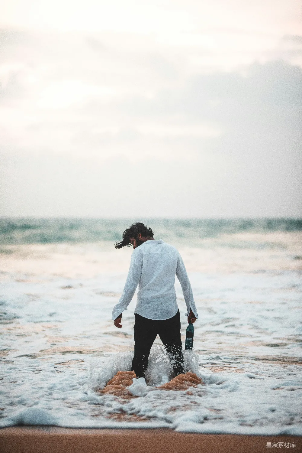 高清摄影 海滩上站着的男人在水中