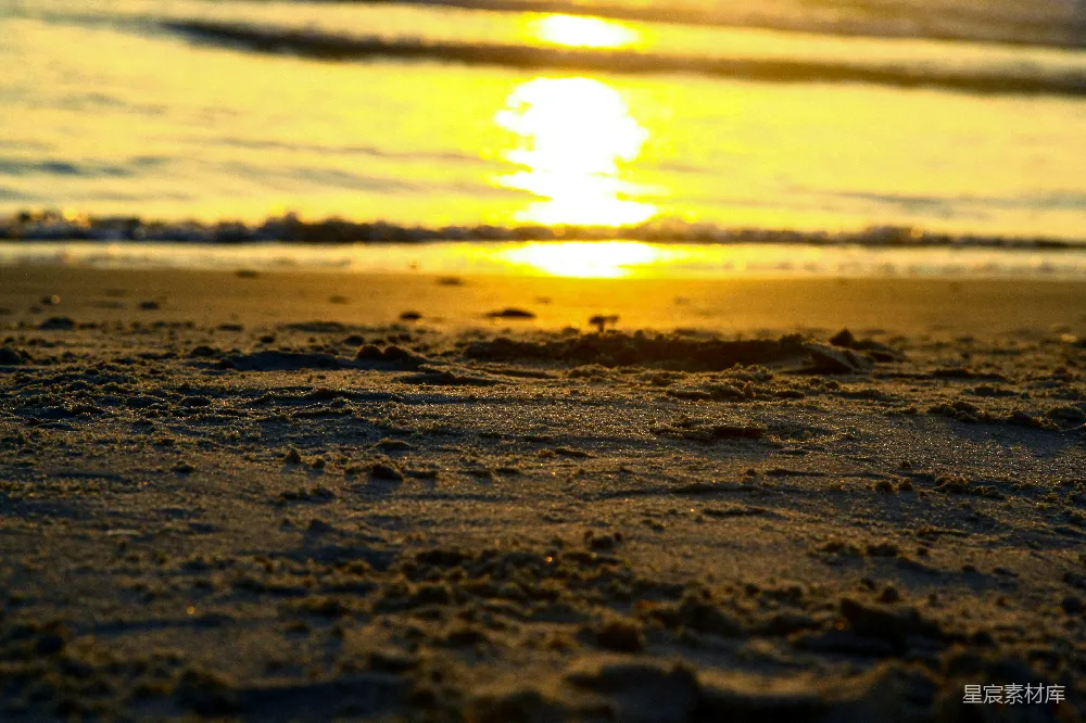 高清摄影 夕阳西下，映照着海滩上的海洋。