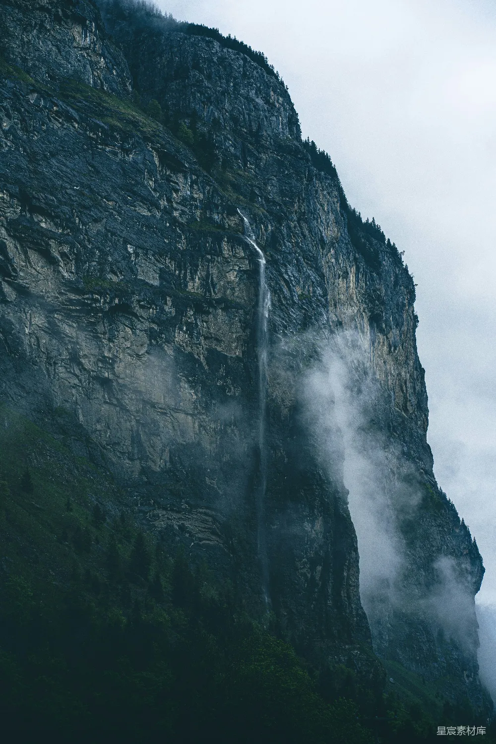 高清摄影 自然 一座高耸的山峰，山脚下有一道瀑布流出来。
