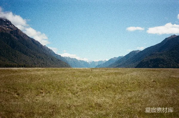 高清摄影 绵延的草地夹在两座森林山脉之间