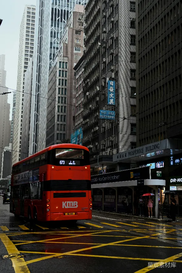 高清摄影 一辆红色的双层巴士正在城市街道上行驶。
