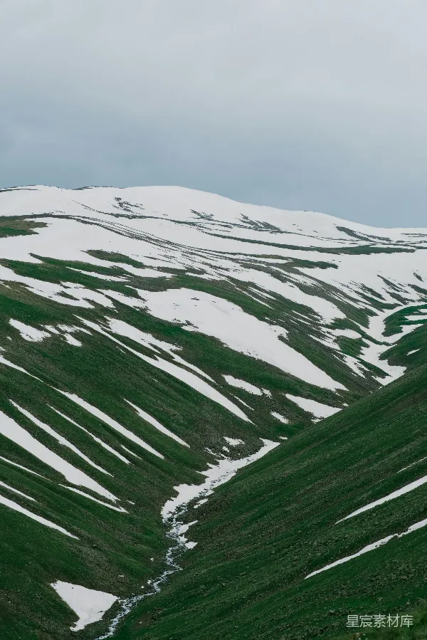 高清摄影 覆盖着白雪的山峦与青草交织