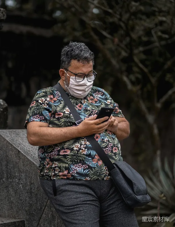 高清摄影 戴口罩的男士在户外使用手机