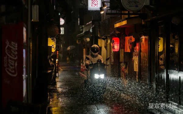 高清摄影 摩托车手在夜晚的一条潮湿、霓虹灯闪烁的小巷中骑行。