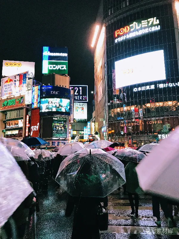 高清摄影 夜晚人们手持雨伞在建筑物附近行走