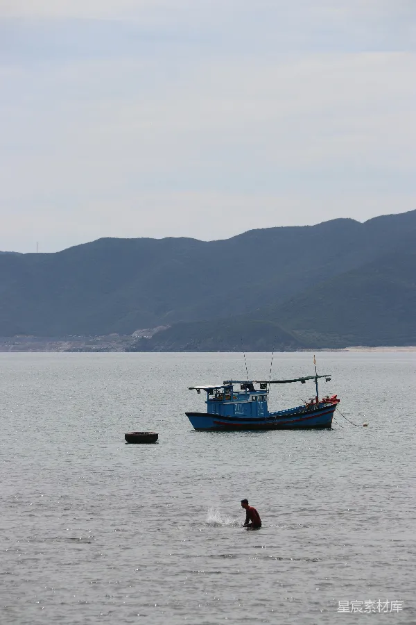 高清摄影 一艘蓝色的捕鱼船浮在平静的海面上。