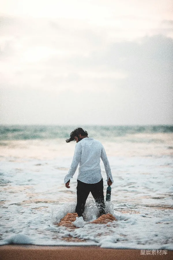高清摄影 海滩上站着的男人在水中