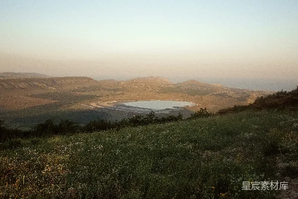 高清摄影 远处有一片草地和一座湖泊的山坡。
