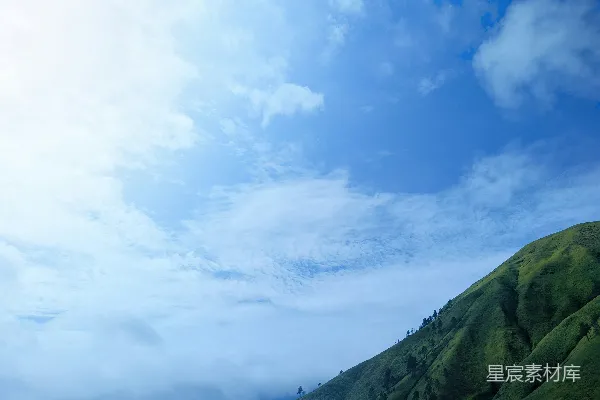 高清摄影 天空中几朵云的一座绿山