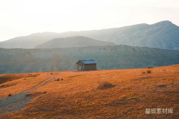 高清摄影 山坡上的一所小屋，背景是山峦。