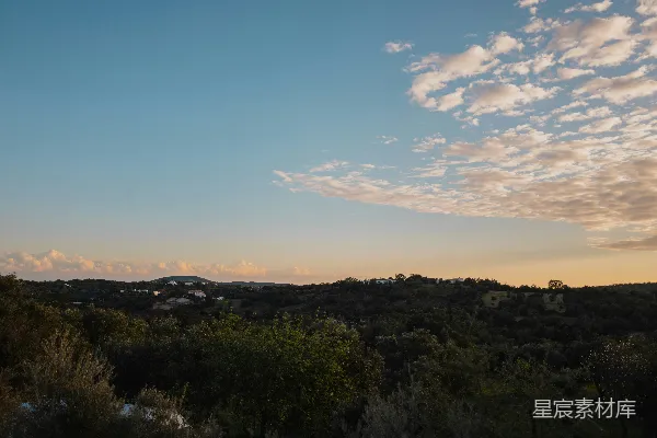 高清摄影 夕阳西下，笼罩着树林和山峦。