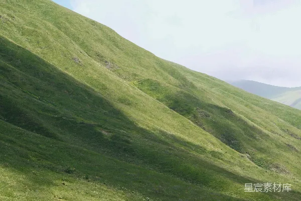 高清摄影 绿草山坡下，云层密布的天空。
