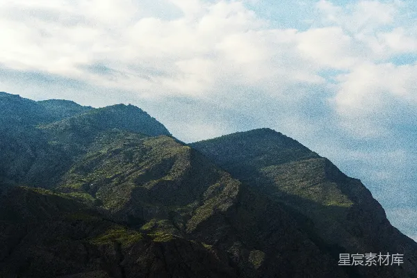 高清摄影 绿山白云间，白昼时分黑山在其中。