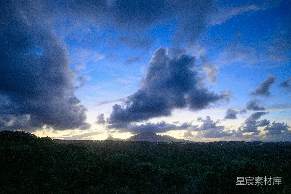 高清摄影 一幅暗林背景下壮丽的日落景象，云朵环绕。