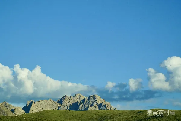 高清摄影 一片广阔的草地，背景是连绵的山峦。