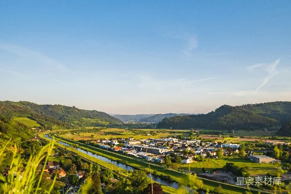 高清摄影 绿谷，夕阳下有城镇和河流。