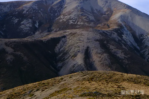 高清摄影 巍峨的山峰耸立在金色草坡之上。