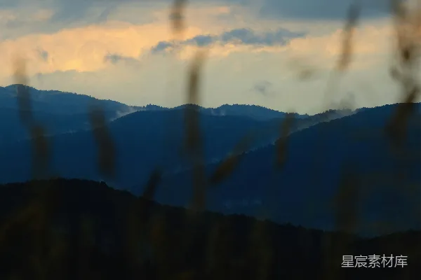 高清摄影 黄昏时分，云层覆盖下起伏的蓝色山峦